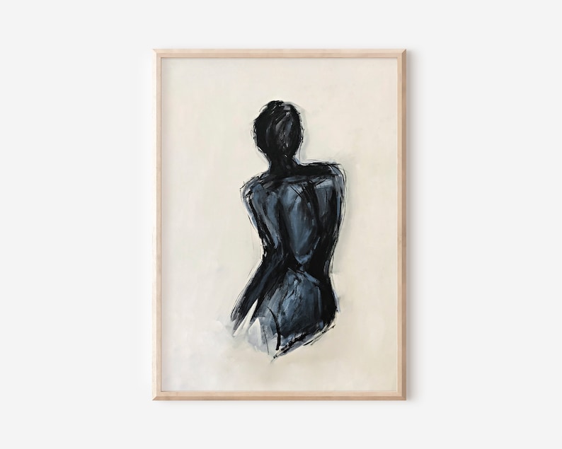 May include: Abstract art print featuring a black and gray figure, viewed from the back, against a cream-colored background. The artwork is framed in a light wood frame, adding a touch of elegance to the piece. The painting has a modern, minimalist aesthetic.