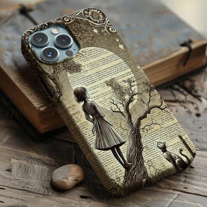 Könnte beinhalten: Handyhülle mit einer sepiafarbenen Vintage-Illustration eines Mädchens, eines Baumes und einer Katze, vor dem Hintergrund alter Buchseiten und eines Mondes. Die Hülle liegt auf einer Holzoberfläche und wirkt klassisch.
