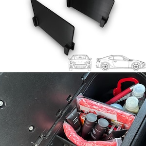 Peut inclure: Deux séparateurs en plastique noir pour la console centrale d'une voiture. Les séparateurs sont conçus pour créer des compartiments de rangement distincts. Les séparateurs sont présentés dans la console centrale d'une voiture avec divers articles rangés dans les compartiments.