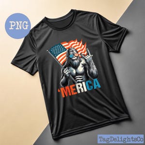 Puede incluir: Camiseta negra con un gr&aacute;fico de un personaje de Bigfoot con gafas de sol y sosteniendo una bandera estadounidense. El dise&ntilde;o incluye la palabra "'MERICA" en rojo, blanco y azul. La camiseta tiene mangas cortas y cuello redondo.