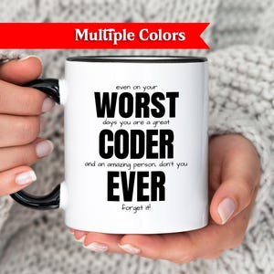 Könnte beinhalten: Weiße Kaffeetasse mit schwarzem Griff und Rand, mit dem Text "even on your WORST days you are a great CODER and an amazing person, don't you EVER Forget it!". Ein rotes Banner oben zeigt "Multiple Colors".