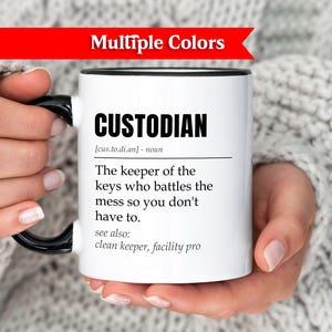 Peut inclure: Mug blanc avec une anse et un bord noirs, portant le mot "CUSTODIAN" en lettres noires en gras. La tasse comprend une définition du mot. Une bannière rouge en haut indique "Multiple Colors".