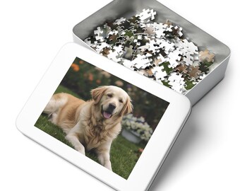 Pode incluir: Uma caixa de quebra-cabeça de metal branco com uma imagem de um cão golden retriever deitado na grama. A caixa está aberta, revelando peças de quebra-cabeça. O cão tem uma pelagem marrom clara e está sorrindo.
