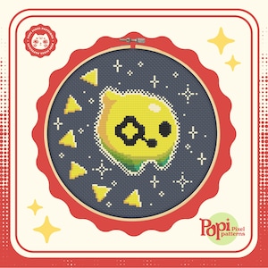 Peut inclure: Un personnage jaune en forme de citron avec un œil et une bouche noirs, entouré d'étoiles blanches et de triangles jaunes sur un fond bleu foncé. Le personnage est dans un cercle de broderie rouge avec une bordure blanche. Le texte "Pop! Pixel patterns" est dans le coin inférieur droit.