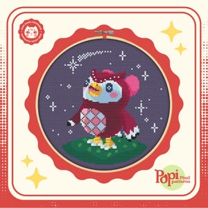 May include: A pixel art cross-stitch pattern of a red and white owl with a pink beak and a blue eye, standing on a green patch of grass under a purple night sky with white stars and a shooting star. The pattern is framed in a red hoop with a white background. The text "Pop! Pixel patterns" is in the lower right corner of the image.