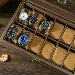 May include: A wooden watch box with a clear lid, featuring 10 compartments for storing watches. The box is made of dark brown wood and has a velvet lining. There are four watches in the box, with different styles and colors.