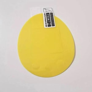 May include: A bright yellow, circular screen protector with a rectangular cutout. The top edge features a white label with the text "FRONT (2)" and instructions. The protector is designed to shield a device's screen from scratches and damage.