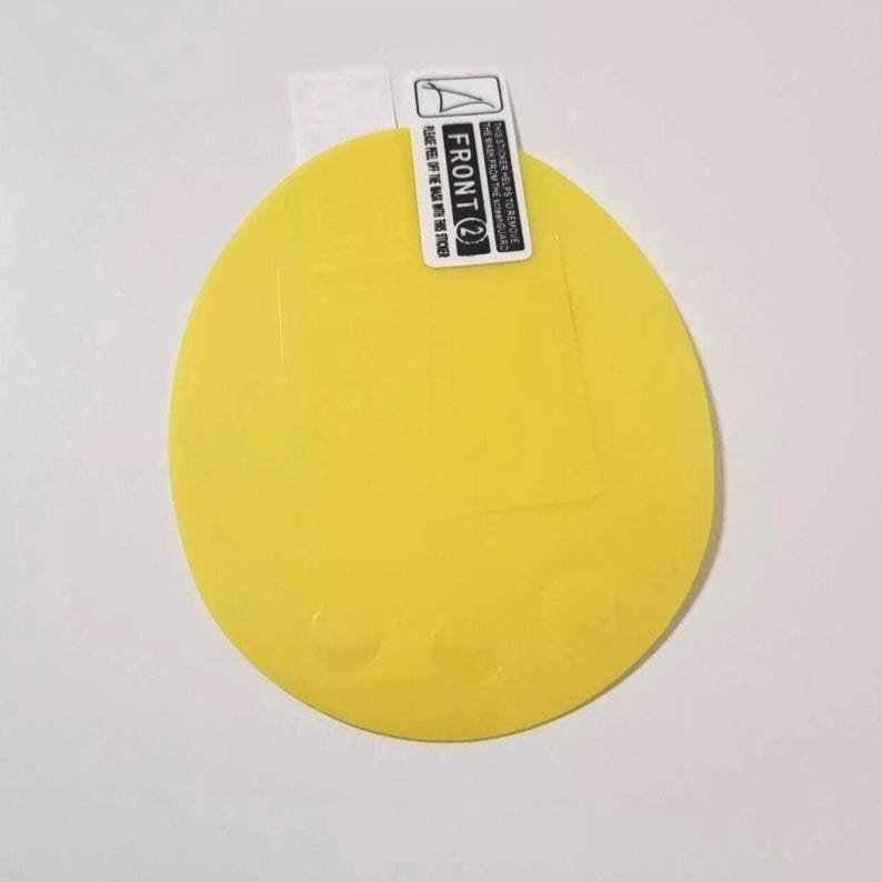 May include: A bright yellow, circular screen protector with a rectangular cutout. The top edge features a white label with the text "FRONT (2)" and instructions. The protector is designed to shield a device's screen from scratches and damage.