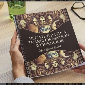 Op de afbeelding: Een donkerbruin spiraalgebonden werkboek met de titel "Hecate's Path: A Transformation Workbook" en de tekst "By Apposite Finds". De omslag toont een illustratie van drie vrouwen met donker haar en een halve maan.