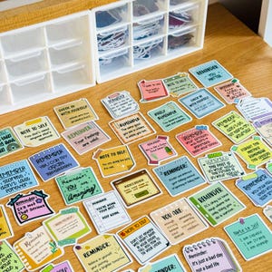 May include: A collection of colourful motivational stickers with positive messages and reminders. The stickers feature various designs and fonts, including phrases like "Note to Self", "Reminder", and "You Are Amazing".