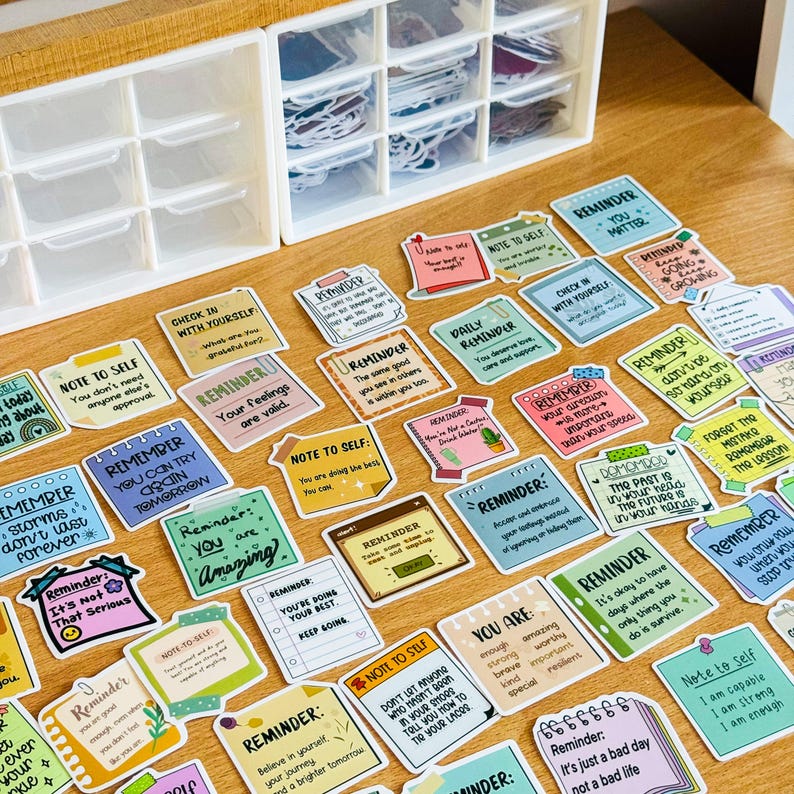 May include: A collection of colourful motivational stickers with positive messages and reminders. The stickers feature various designs and fonts, including phrases like "Note to Self", "Reminder", and "You Are Amazing".