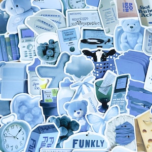 May include: A collection of blue and white stickers featuring various designs, including a teddy bear, a cow, a butterfly, a clock, a glass of water, a bottle, a star, a cloud, a record player, a phone, and a glass of blueberries. The stickers have a vintage aesthetic and are perfect for adding a touch of whimsy to any project.