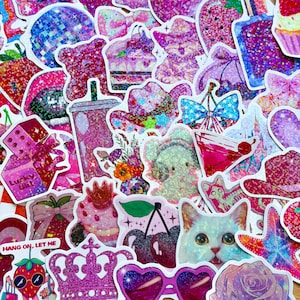 May include: A collection of colorful stickers with glitter accents. The stickers feature various designs, including a disco ball, strawberries, a cat, a crown, and sunglasses. The color palette is primarily pink and purple.