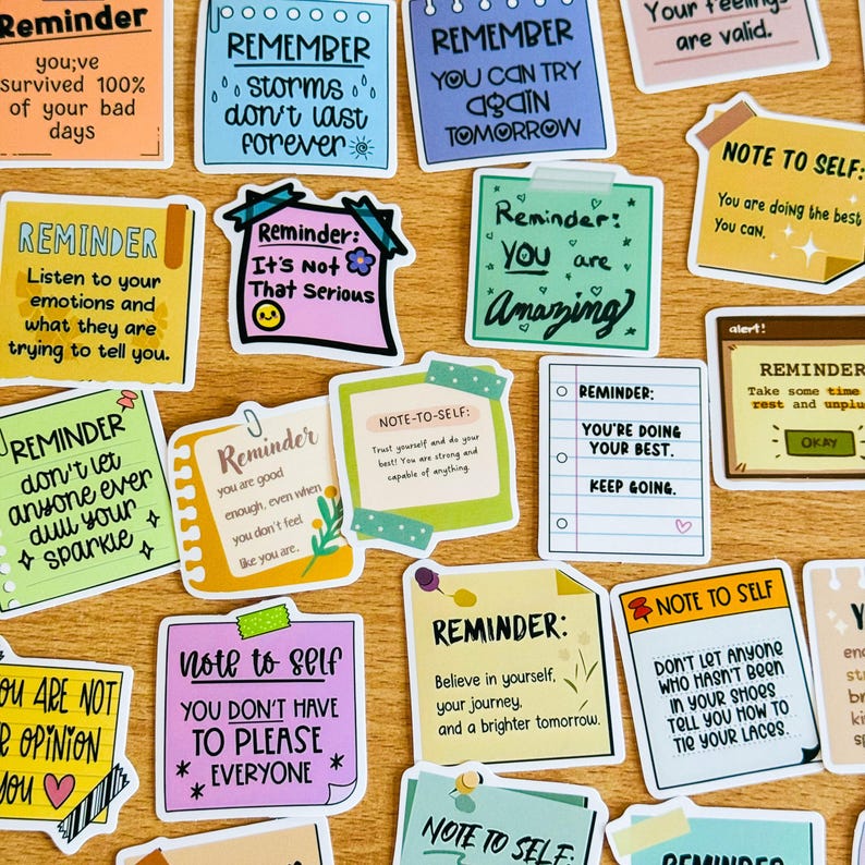May include: A collection of colourful motivational reminder stickers with positive messages. The stickers feature phrases like "Remember storms don't last forever", "You are amazing", and "You're doing your best, keep going".