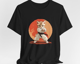 May include: Black t-shirt with a graphic of a cat wearing a white karate uniform and a black belt, standing in a fighting pose in front of a red and orange sun.