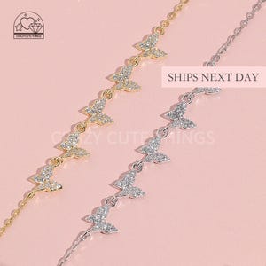 May include: Two delicate butterfly necklaces with sparkling crystal accents. One necklace is gold and the other is silver.