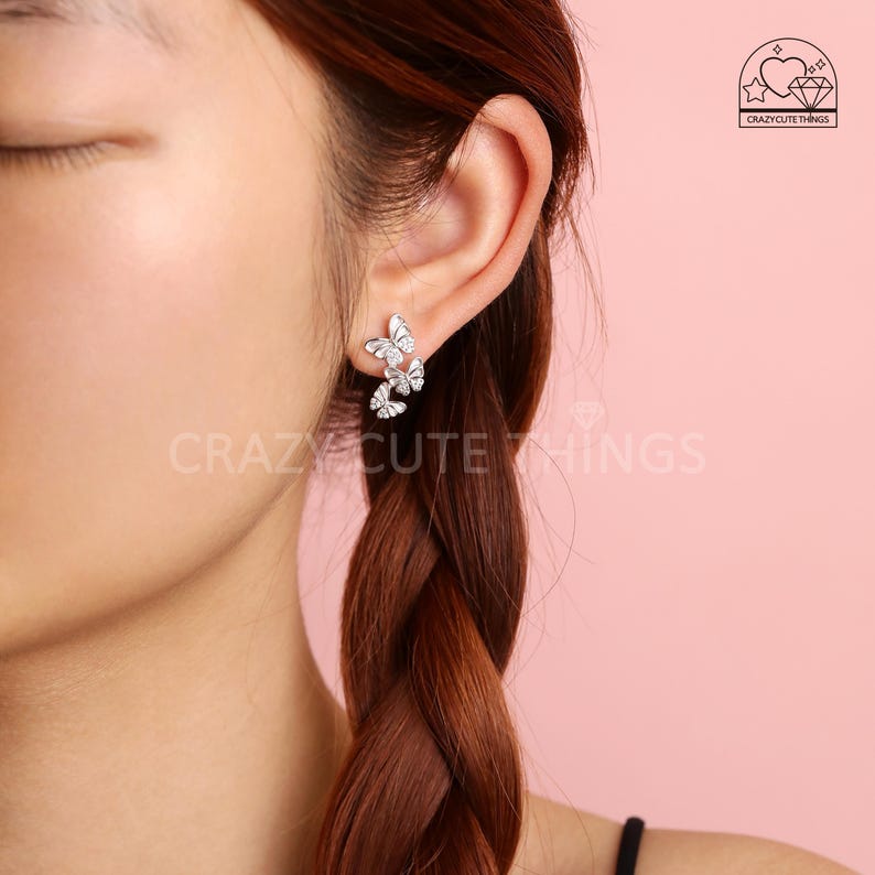 May include: Silver butterfly earrings with clear crystals. The earrings are designed to look like a cluster of butterflies.