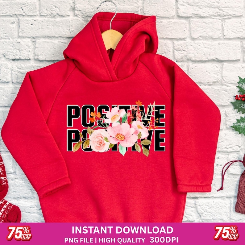 May include: A red hoodie with the word "POSITIVE" in black block letters, with a floral design in the center. The flowers are pink, white, and orange. The hoodie is hanging on a wooden hanger.