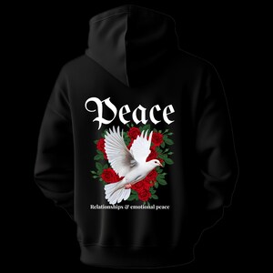 May include: Black hoodie featuring a white dove with outstretched wings, surrounded by red roses and green leaves. The word "Peace" is written above the dove in a decorative font. Below the dove, the text reads "Relationships & emotional peace."