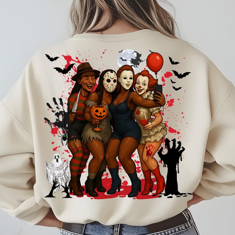 K&ouml;nnte beinhalten: Beiges Sweatshirt mit einem Halloween-Motiv. Das Design zeigt Illustrationen von ikonischen Horrorfiguren, Flederm&auml;usen, einem Vollmond und einem roten Ballon. Die Figuren sind in einer Gruppe dargestellt, wobei eine ein Selfie macht.