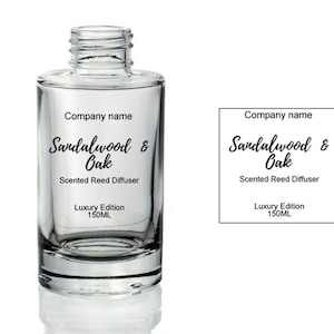 May include: A clear glass bottle with a black label that reads "Company name Sandalwood & Oak Scented Reed Diffuser Luxury Edition 150ML".