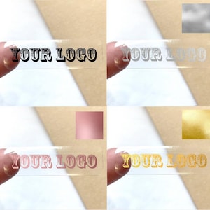 May include: Four clear rectangular stickers with the text "YOUR LOGO" in a decorative font. The stickers are shown on a brown surface and have different coloured foil backgrounds: black, silver, rose gold, and gold.