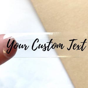 May include: Clear rectangular sticker with the text "Your Custom Text" printed in black.