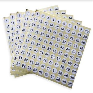Könnte beinhalten: Mehrere Bögen mit runden, weißen Aufklebern mit schwarzen Zahlen von 1 bis 100. Die Aufkleber sind auf einem beigefarbenen Hintergrund angeordnet. Ideal zum Beschriften.
