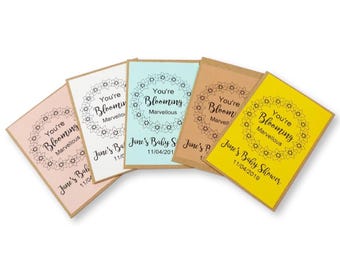30 sobres con semillas para baby shower personalizados con la frase "You're blooming marvelous" en color rosa, azul y amarillo