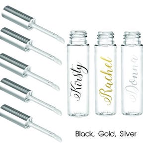 May include: Five clear lip gloss tubes with silver caps and applicators. The tubes are labelled with the names "Kirsty", "Rachel", and "Donna" in black, gold, and silver lettering.
