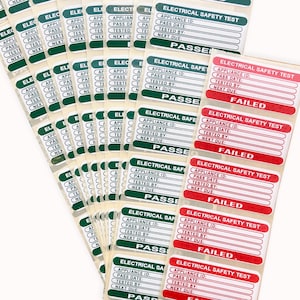 May include: A stack of green and red electrical safety test labels. The labels have fields for appliance ID, pass date, tested by, and next due. Some labels are marked "PASSED" and others are marked "FAILED".