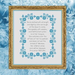 May include: A framed cross-stitch design with a blue floral border and a white background. The text reads: "She is clothed with strength and dignity; she can laugh at the days to come. She speaks with wisdom, and faithful instruction is on her tongue. She watches over the affairs of her household and does not eat the bread of idleness. Her children arise and call her blessed. Proverbs 31:25-28a"