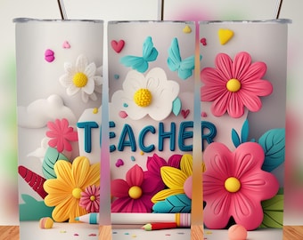 Op de afbeelding: Een witte beker met een bloemenontwerp en het woord 'TEACHER' in blauwe letters. Het ontwerp bevat roze, gele en witte bloemen, blauwe vlinders en een potlood. De beker heeft een zilveren rietje.