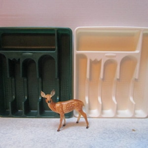 May include: Two plastic cutlery trays, one green and one white, with five compartments each. A small brown and white deer figurine is in front of the trays.