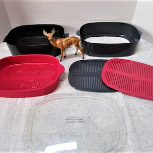May include: A set of four kitchen containers with lids. Two of the containers are black and two are red. The containers have a grid pattern on the bottom. The containers are made of plastic.