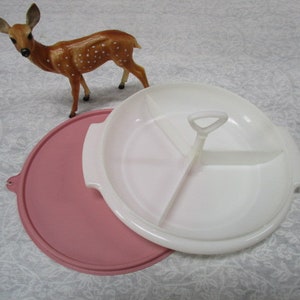 May include: A white plastic divided serving dish with a pink lid. The dish has three sections and a handle in the center.