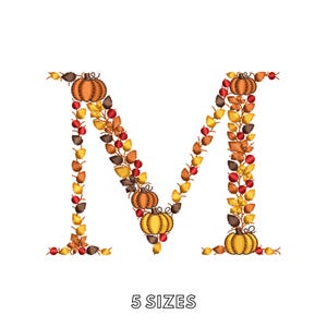 May include: An embroidered letter M formed by autumn-themed elements including orange pumpkins, yellow, brown, and red leaves, and small red berries. The design features a repeating pattern of foliage and gourds. The text 5 SIZES appears below.
