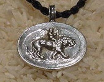 May include: Silver pendant necklace featuring a detailed relief of a rider on horseback. The pendant is oval shaped and hangs from a black cord.