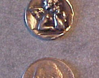May include: Silver pendant necklace featuring a raised image of an angel with wings. The pendant is about the size of a UK 20 pence coin.