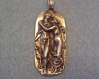 May include: A bronze pendant depicting a couple embracing, with a stylized background.
