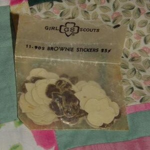 May include: A package of Girl Scout Brownie stickers with the Girl Scout logo and the text "11-902 Brownie Stickers 25&cent;".
