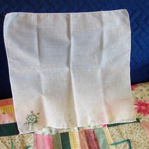 May include: White cotton handkerchief with a green embroidered clover design.