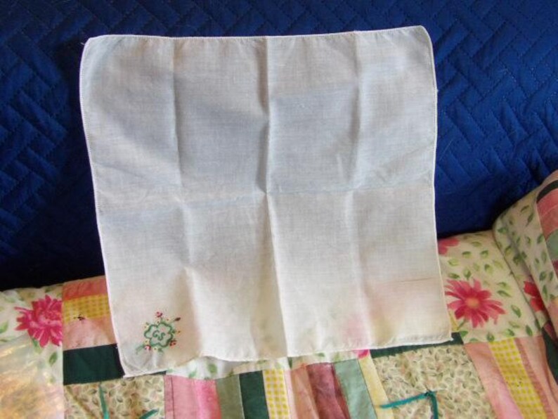 May include: White cotton handkerchief with a green embroidered clover design.