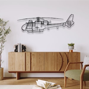 May include: A black metal helicopter wall art piece. The helicopter is depicted in a side profile, with detailed outlines of the cockpit, rotor blades, and tail. The artwork is mounted on a white wall above a wooden cabinet.