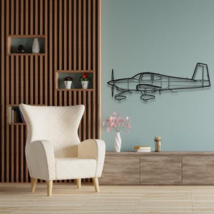 May include: A black metal airplane wall art piece. The airplane is a detailed outline, featuring a propeller, wings, and fuselage. It is mounted on a light blue wall, adding a modern touch to the room's decor. The room also features a cream-colored armchair and wooden shelves.