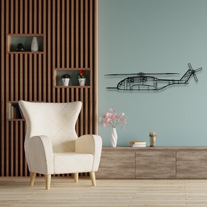 May include: A black metal silhouette of a helicopter mounted on a light blue wall. The helicopter is in flight with the blades spinning. A white armchair with wooden legs sits in front of the wall.