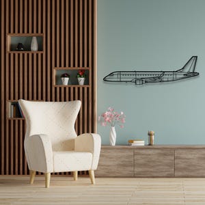 May include: A black metal airplane silhouette wall decor mounted on a light blue wall above a white armchair with wooden legs. The wall behind the airplane is a wood panel with vertical slats.