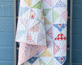 Colcha infantil o para niños pequeños con diseño de campanillas azules y ranúnculos.