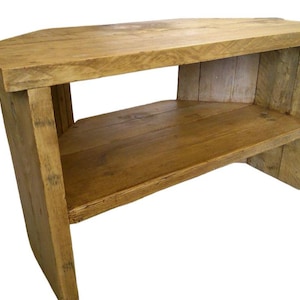 May include: A corner TV stand made of reclaimed wood with a natural finish. The stand has one shelf and is approximately 30 inches wide.