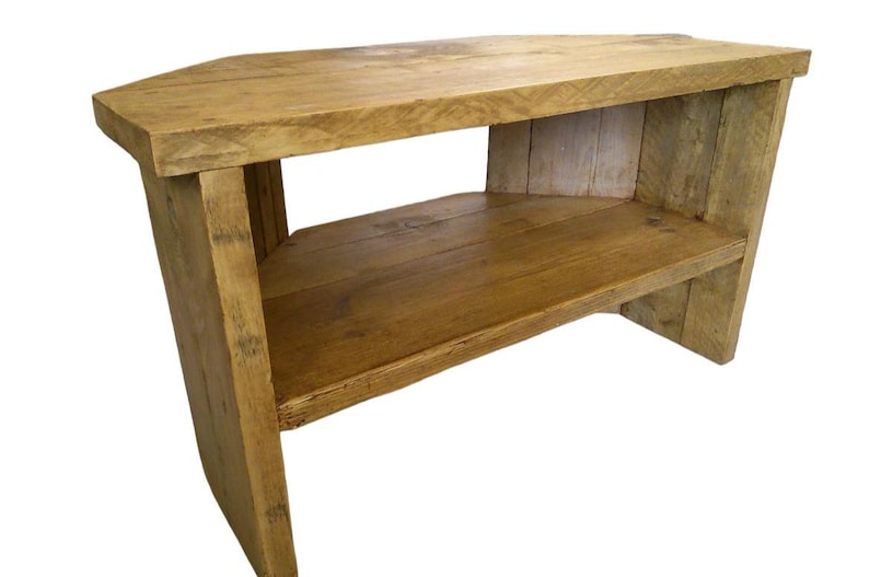 May include: A corner TV stand made of reclaimed wood with a natural finish. The stand has one shelf and is approximately 30 inches wide.